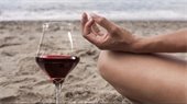 yoga on beach with glass of wine
